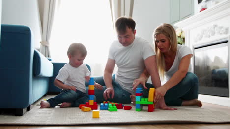 Glückliche-Familie,-Vater,-Mutter-Und-Baby-2-Jahre,-Die-In-Ihrem-Hellen-Wohnzimmer-Lego-Spielen.-Zeitlupenaufnahmen-Einer-Glücklichen-Familie