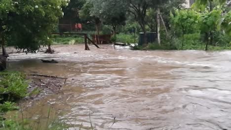 arroyo de inundación que ruge entre los jardines después de fuertes lluvias