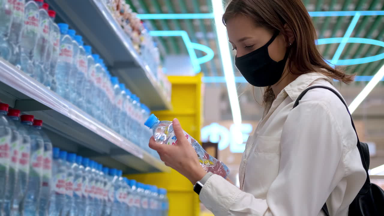 슈퍼마켓 에서 물 병 을 구입 하는 여자