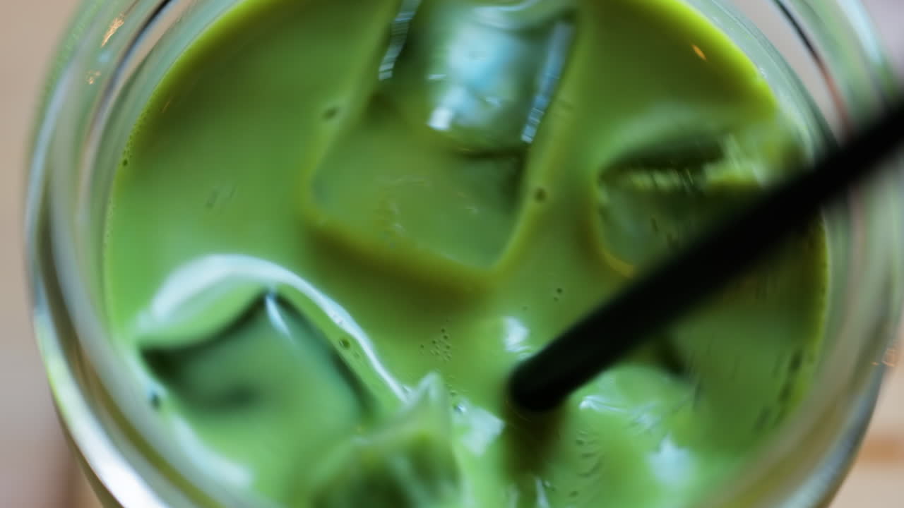 Close up of a glass of an iced matcha on a table at a cafe