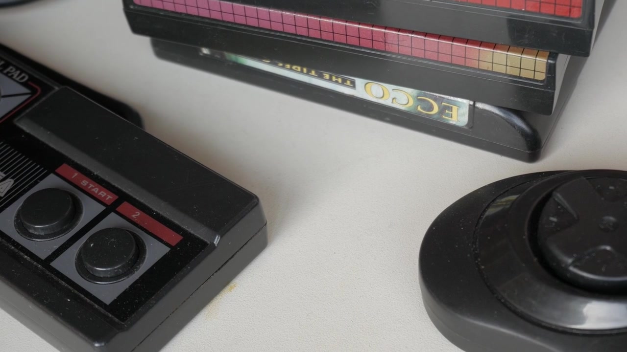 Vista macro che scorre su un controller per videogiochi blu e nero e cartucce per videogiochi.