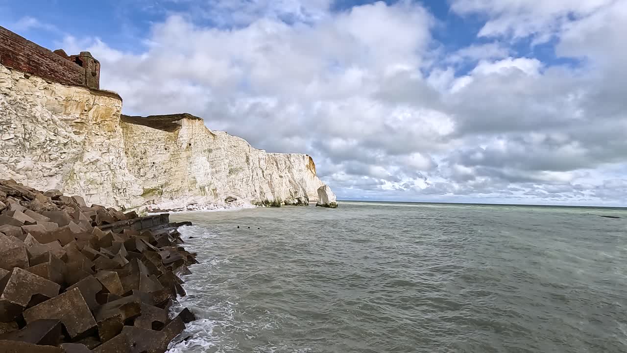 волны бьются о скалы в восточном сассексе, англия