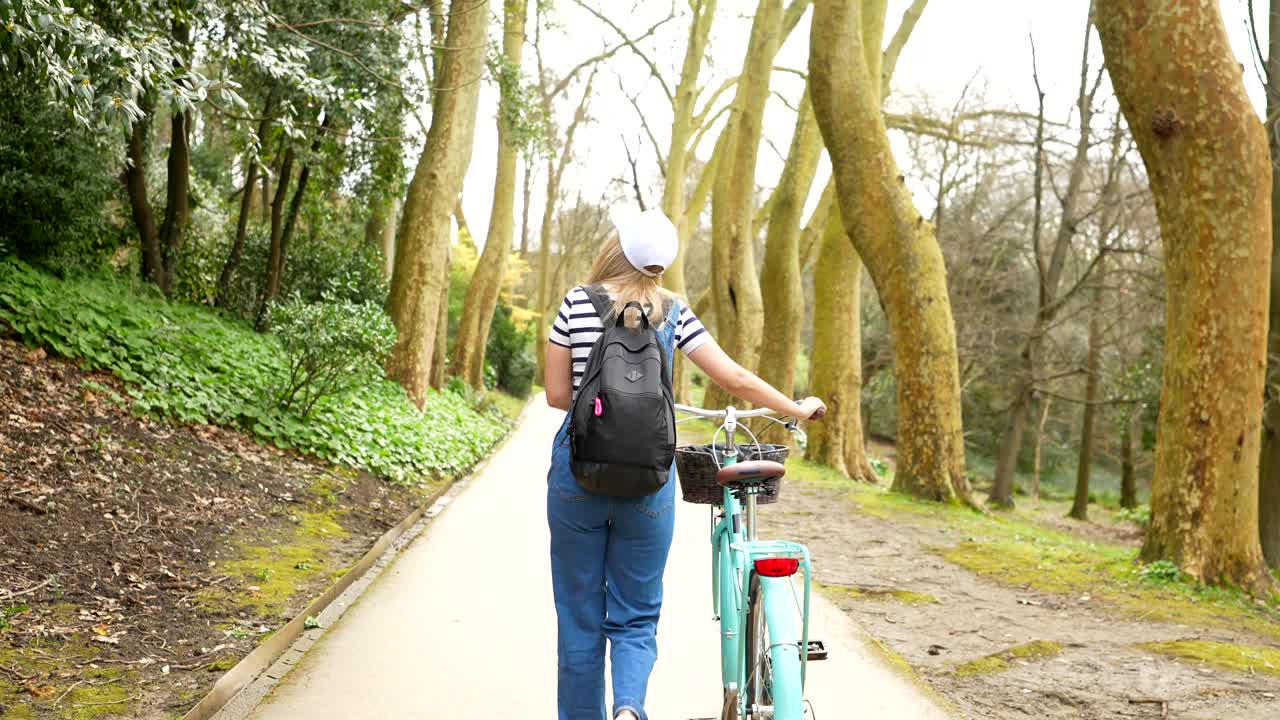 Woman walking with bicycle in park
