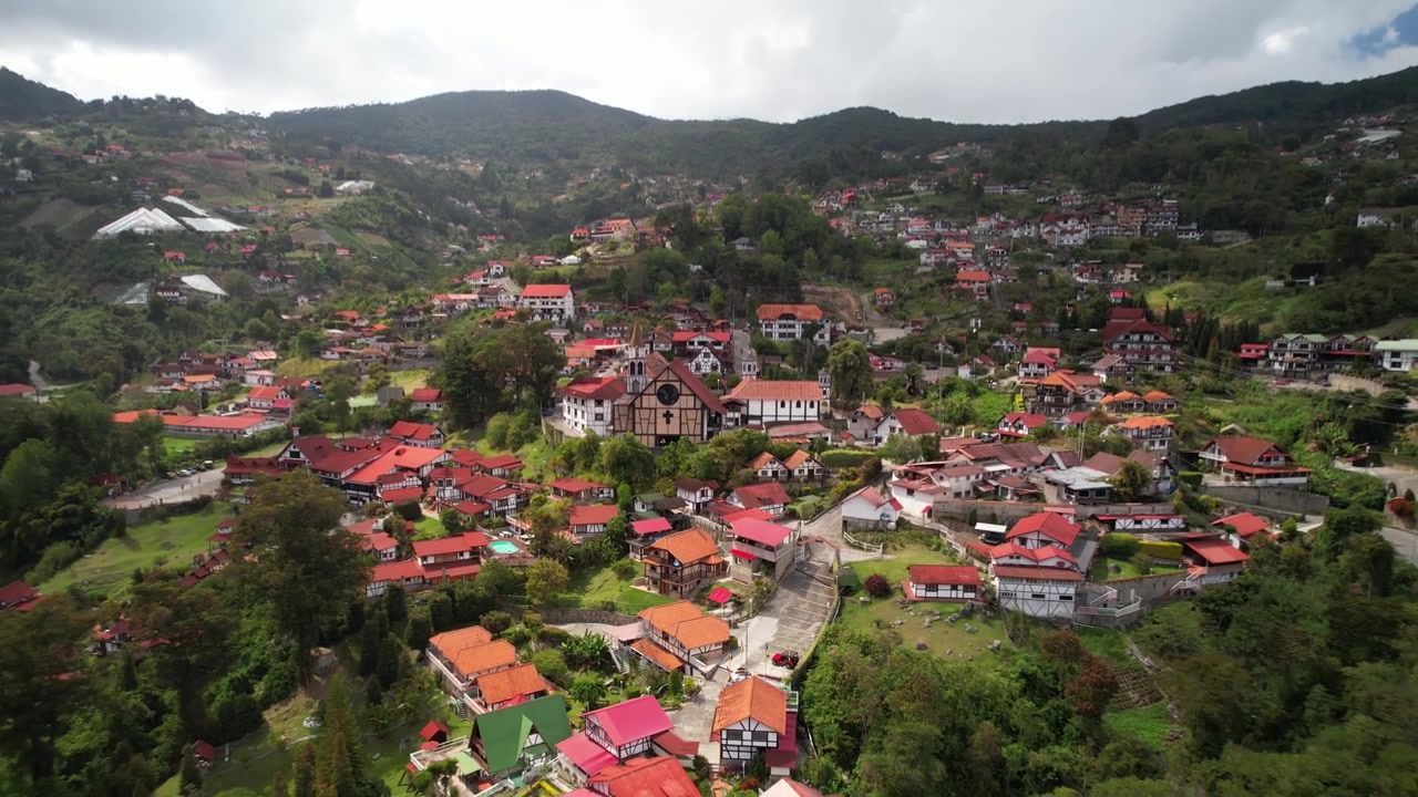 Dézoom de drone sur le village de montagne de style allemand Colonia Tovar, dans un paysage tropical verdoyant