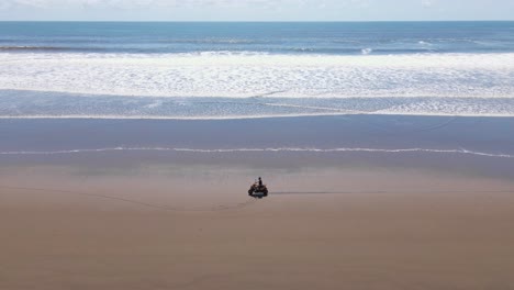 Luftaufnahme,-Die-Ein-ATV-Fahren-Am-Strand-Verfolgt