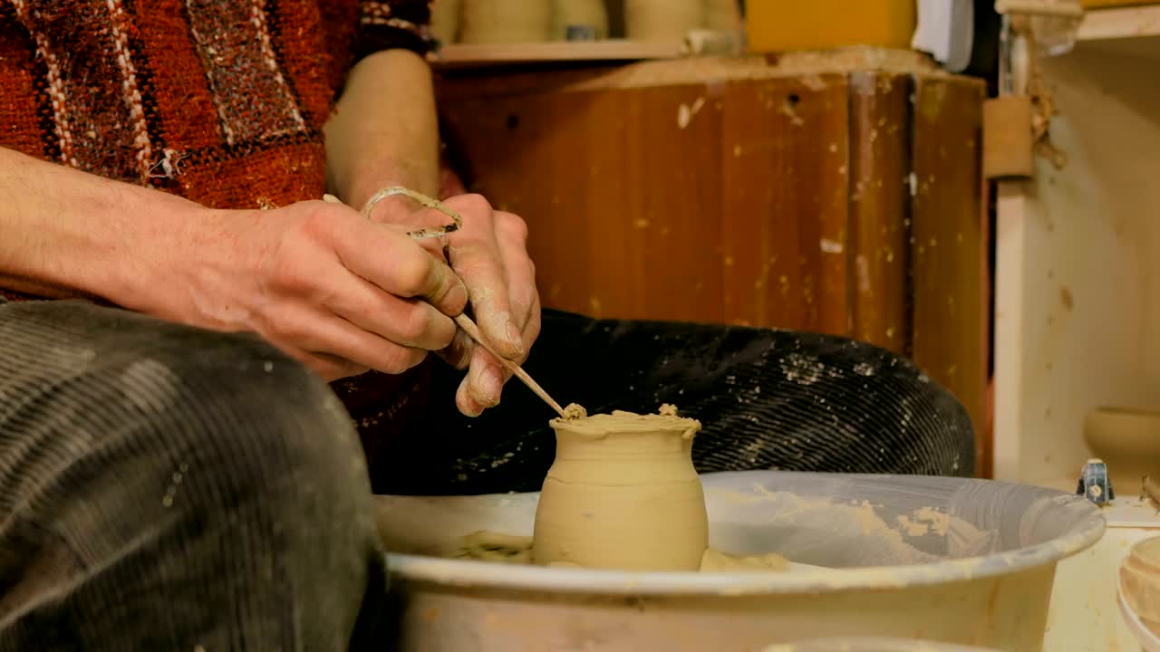 taza de tallado de alfarero profesional con herramienta especial en taller de cerámica