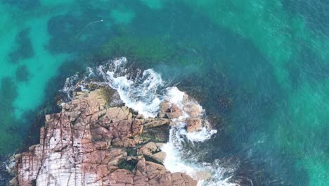 Nature's-Palette:-Aerial-View-of-Rocky-Shores-Meeting-Azure-Waters