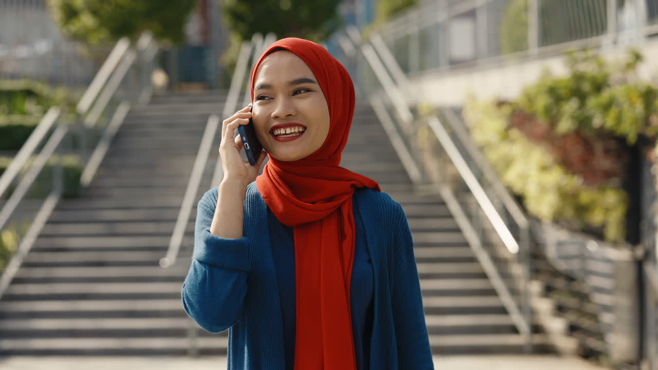 Young Muslim Woman in Hijab Talking on Phone Outdoors