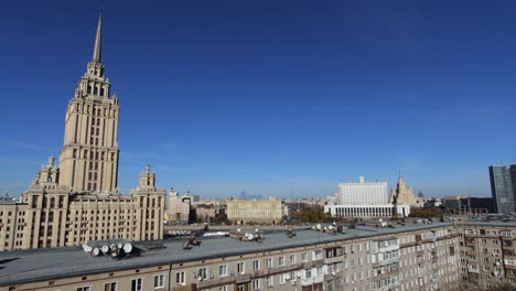 time lapse view of the a seven sister building in moscow and the white house in front of a blue sky