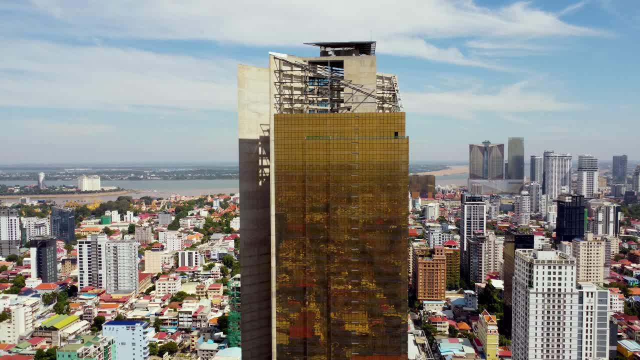 en construcción de un edificio rascacielos, phnom penh torre de oro 42 fachada de pared de vidrio dorado, disparo de avión no tripulado