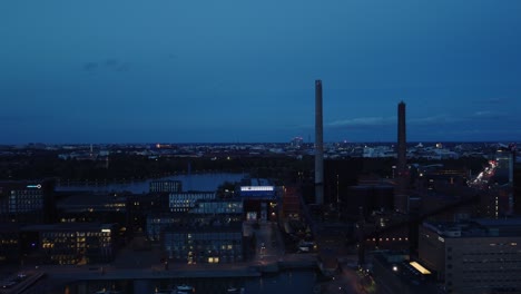 Aerial-dolly-shot-of-industrial-smoke-stacks-in-port-of-Helsinki,-FIN