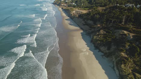 drone shot of waves rolling once a newport beach in oregon