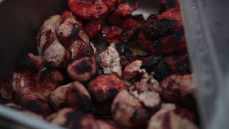 Slow-motion-shot-showing-a-chef-picking-up-a-selection-of-cooked-meats