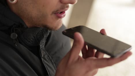 Slow-motion-shot-of-young-man-recording-voice-message