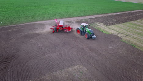 Landwirtschaftlicher-Traktor-Mit-Anhängersämaschine,-Der-Sich-Auf-Gepflügtem-Land-Bewegt.-Sämaschine