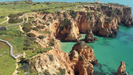 idyllic mediterranean coastline of ponta da piedade, lagos, algarve, portugal - aerial wide fly-over shot