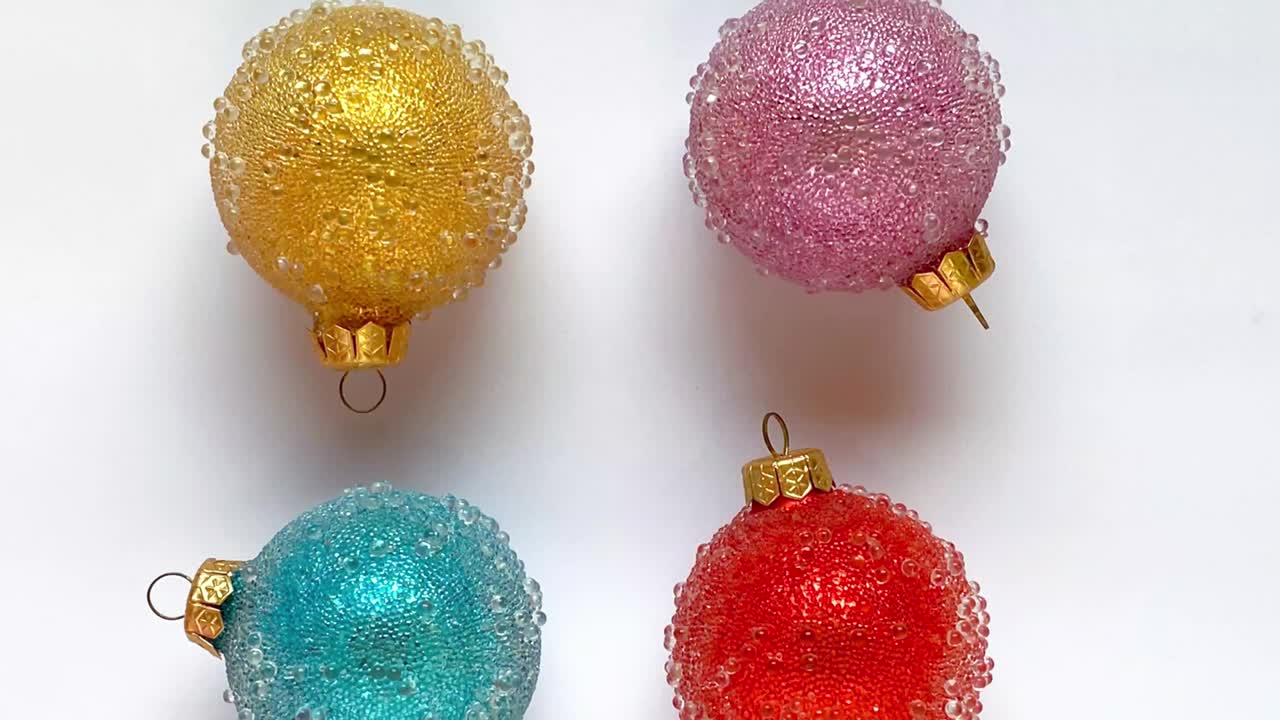 las bolas de navidad amarillas, verdes, azules, rosas están bailando en animación stop motion