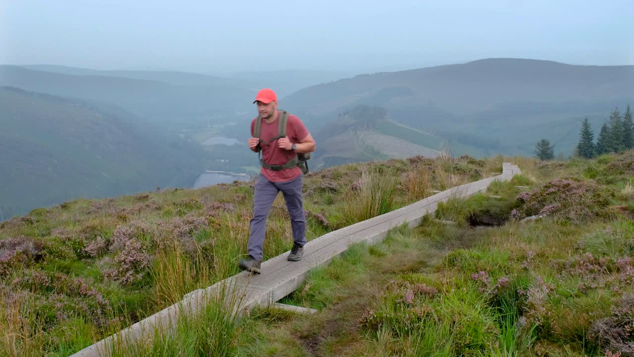 Turist på gangbro i Wicklow nasjonalpark.