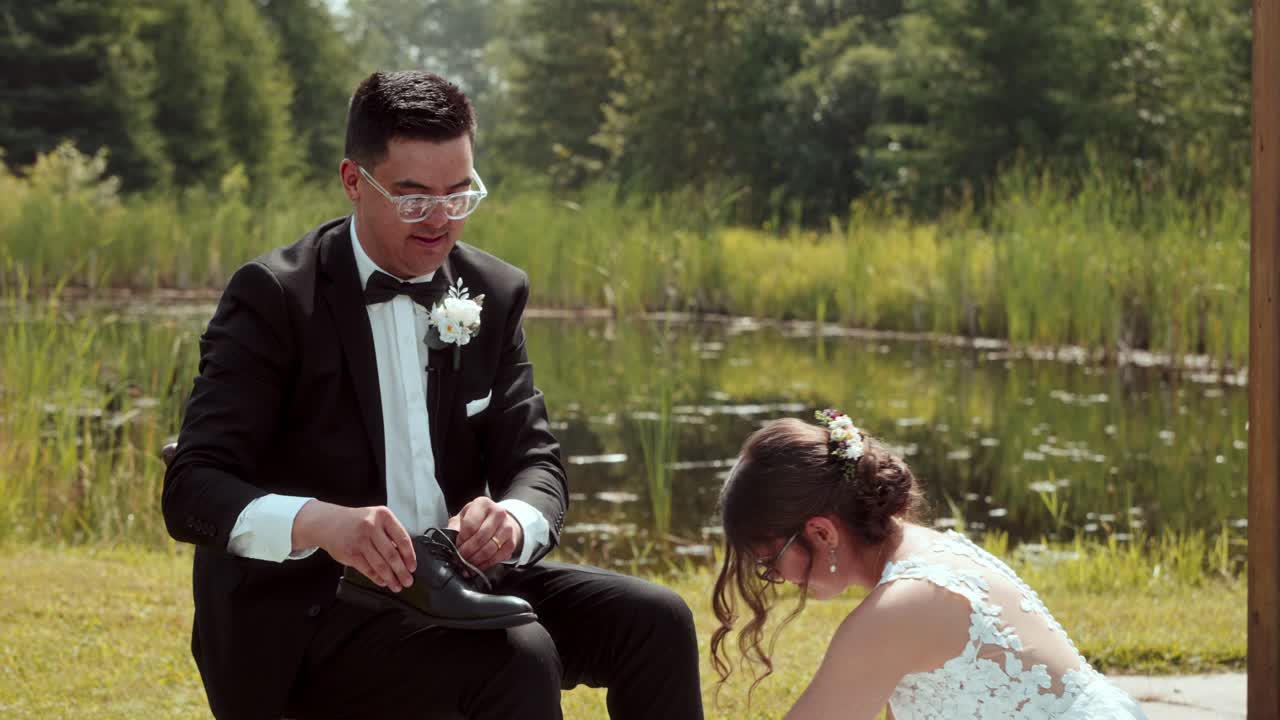 Slow-motion foot washing ritual as bride kneels and groom sits during vows