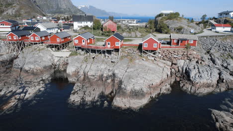 Fantastic-traveling-out-over-beautiful-red-houses-in-the-town-of-Hamnoy-with-mountains-in-the-landscape