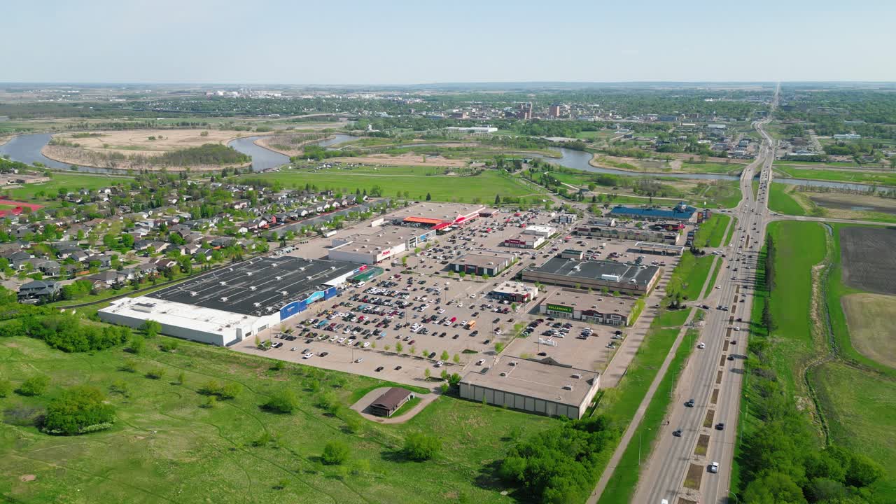 Drone zooms out from Brandon’s Corral Centre; cars bustle under the summer sun