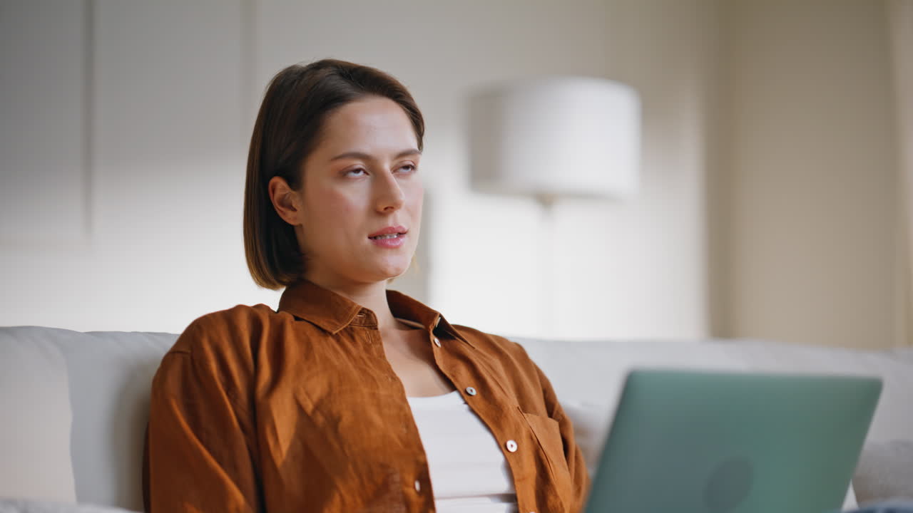 Relaxed startuper looking laptop sitting at home couch closeup. Woman working