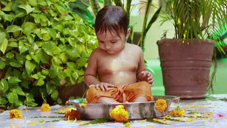 cute toddler baby boy bathing in decorated bathtub at outdoor from unique perspective