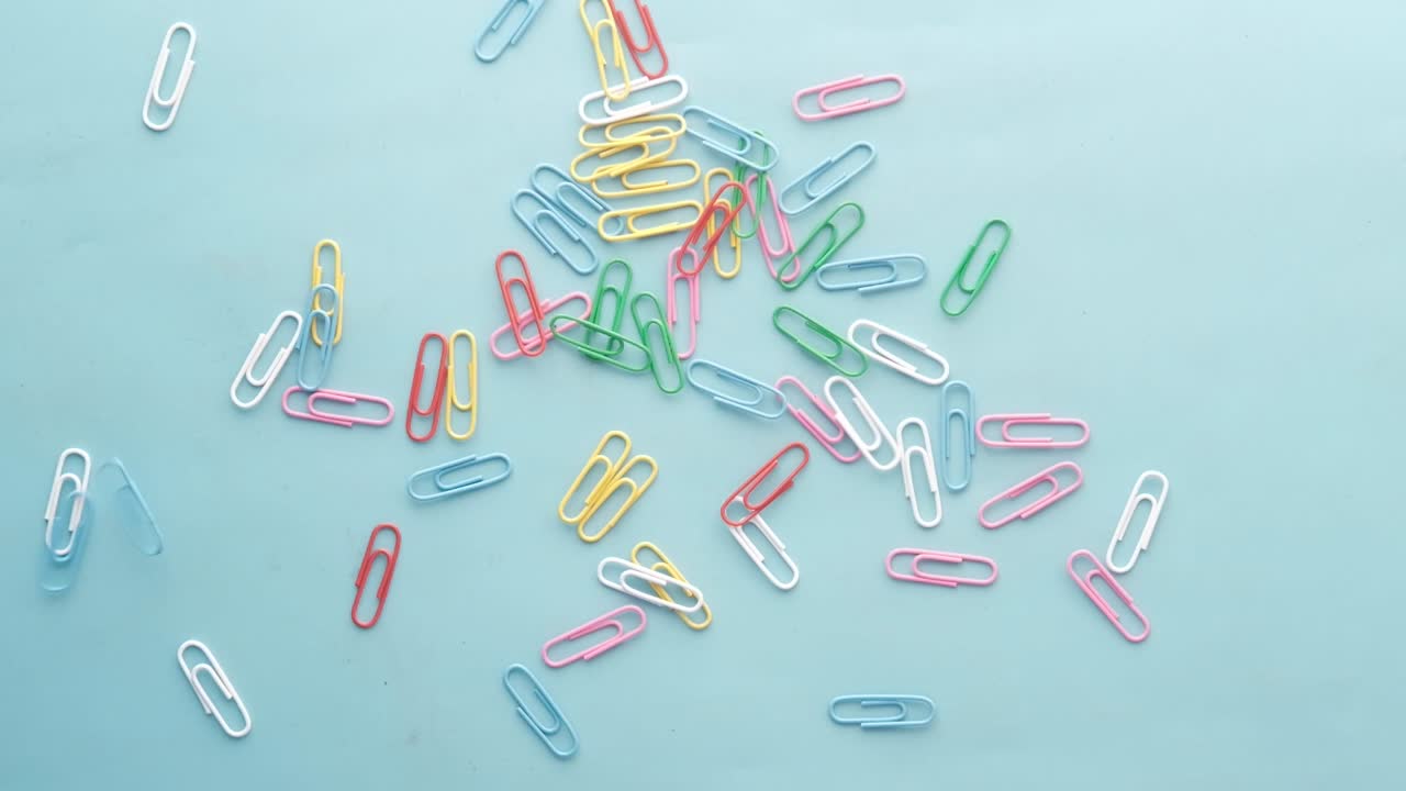 밝은 파란색 표면에 다채로운 종이 클립