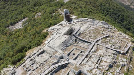 drone approaching the ancient historical landmark of perperikon, revealing a water reservoir and a tower at the edge of the palace complex, located in kardzhali province in bulgaria