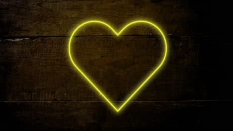 animación de un corazón de neón amarillo parpadeando sobre un fondo de madera oscura