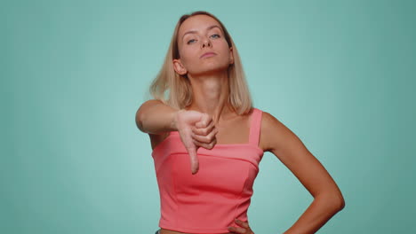 Upset-woman-in-casual-crop-top-showing-thumbs-down-sign-gesture,-disapproval,-dissatisfied-dislike