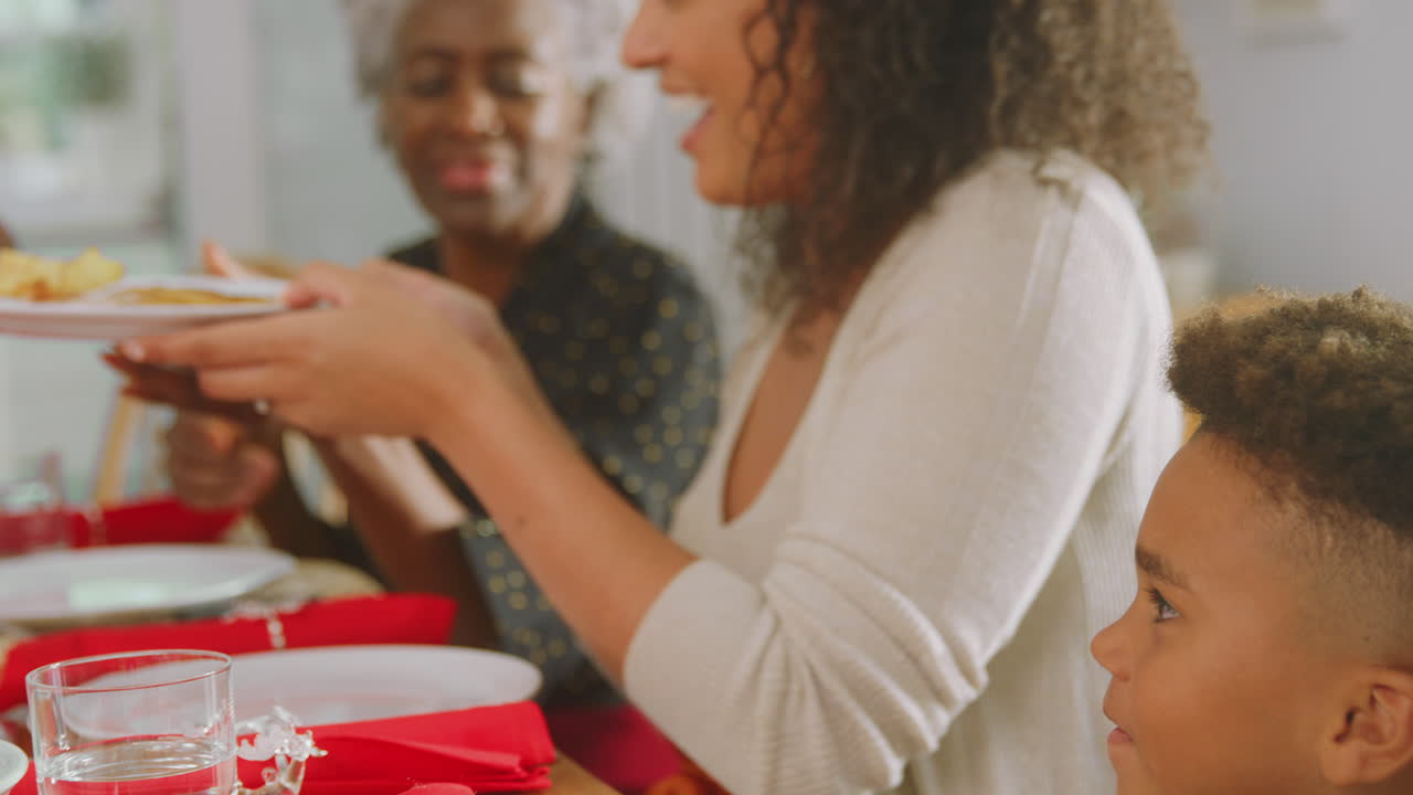 el abuelo tallando y sirviendo como familia de varias generaciones disfrutan comiendo la comida de navidad en casa