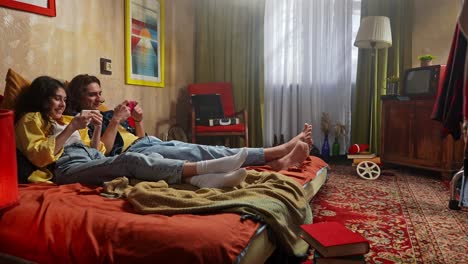 young couple playing games in a retro bedroom