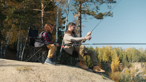 father and son fishing in autumn forest