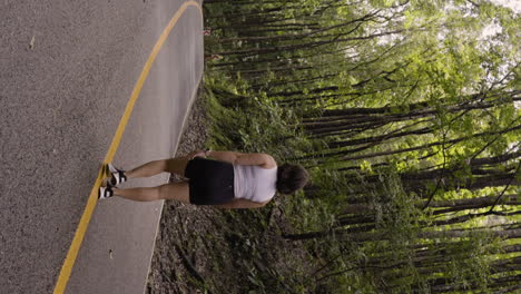 Vertical-slow-motion-shot-of-a-female-walking-along-a-yellow-line-in-a-forest-in-Bohol