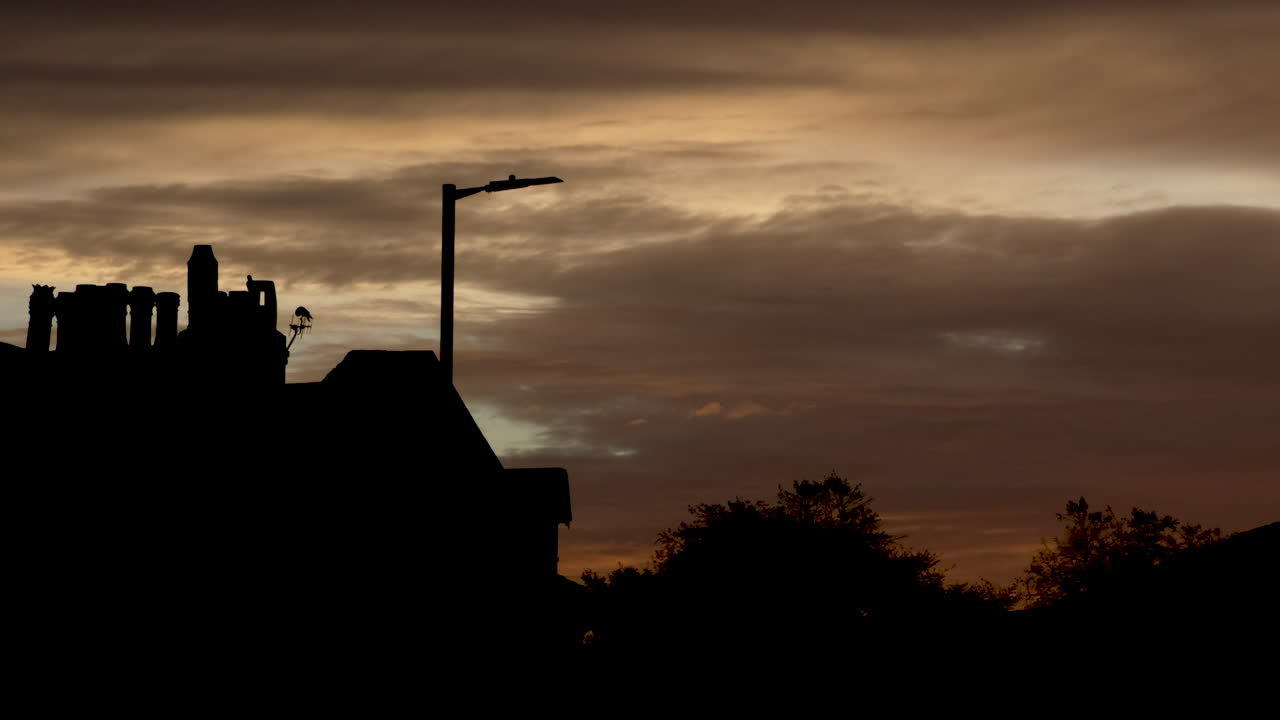 Todmorden skyline at sunset with golden and brown skies as buildings stand in dark silhouette against the glowing horizon