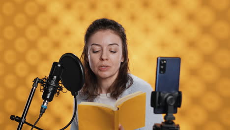 narradora mirando la cámara del teléfono, filmándose a sí misma leyendo un libro para niños