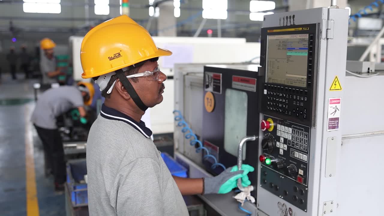 works are watching a CNC machine display in factory. Industry 5.0, industrial 4.0 concept