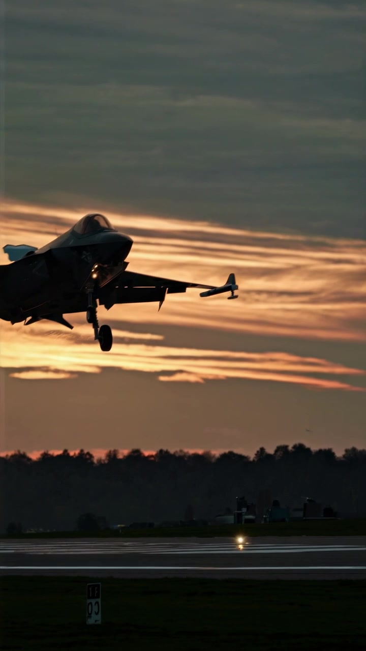 Jet da combattimento F-35 che atterra su una pista al tramonto