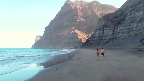 Idyllic-scene-of-two-people-at-unspoiled-virgin-beach-in-Gran-Canaria,-Spain-during-summer-time-on-vacations