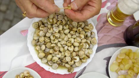 jedzenie gotowanych ślimaków, escargot z talerza, pyszne portugalskie jedzenie