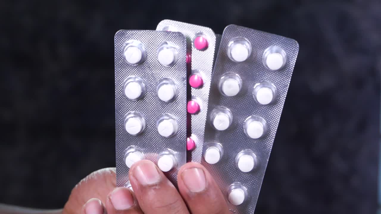 Mano sosteniendo blísteres de pastillas