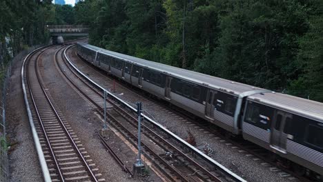 aerial view of passing american metro on railroad in scenic area of atlanta city during cloudy day - static wide shot