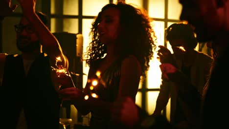 friends holding sparklers at nightclub party