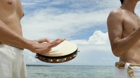 hombres sin camisa tocando instrumentos musicales