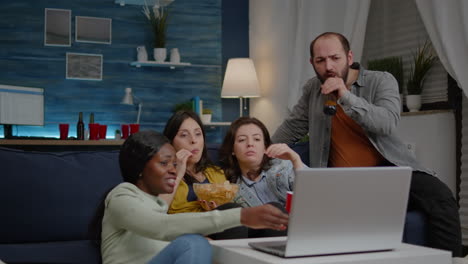 Multiracial-friends-chilling-on-sofa-in-living-room-during-movie-night