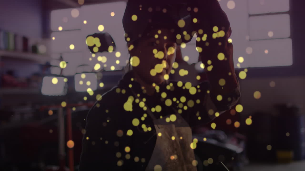 welder lifting helmet in industrial workshop, featuring animated sparks and data icons