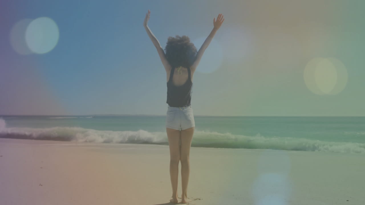 Standing on beach, person raising arms facing ocean waves, imagining animation