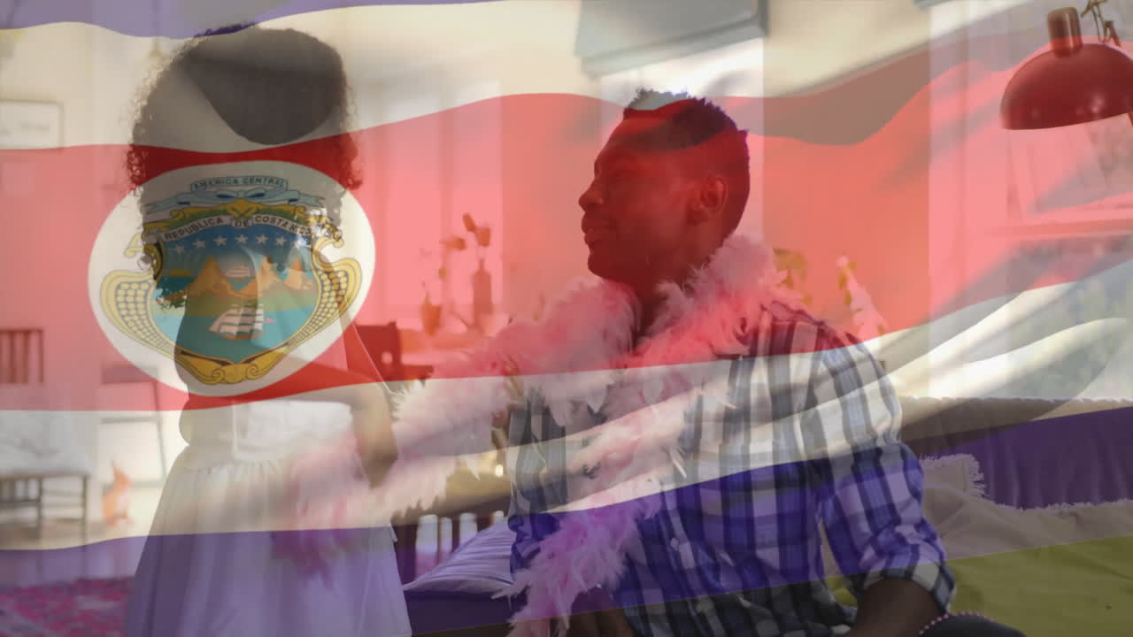 Child placing pink feather boa on man over Costa Rica flag animation