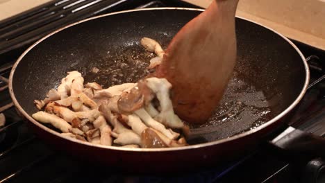 pan of fresh oyster mushrooms and garlic in a skillet sauteing in mutter